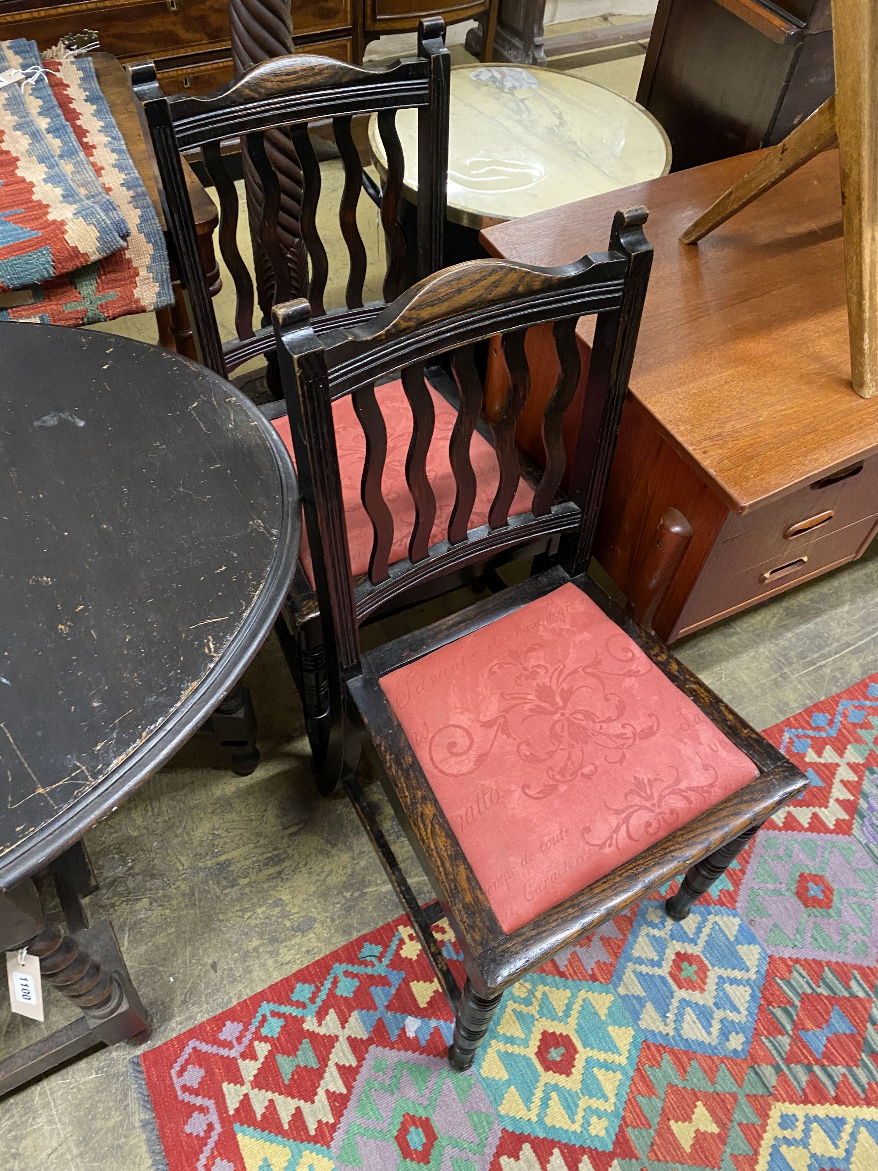 An early 20th century oak oval gateleg table, 106cm extended, width 74cm, height 74cm together with two oak dining chairs